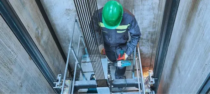 a technician inspecting elevator cables for damage